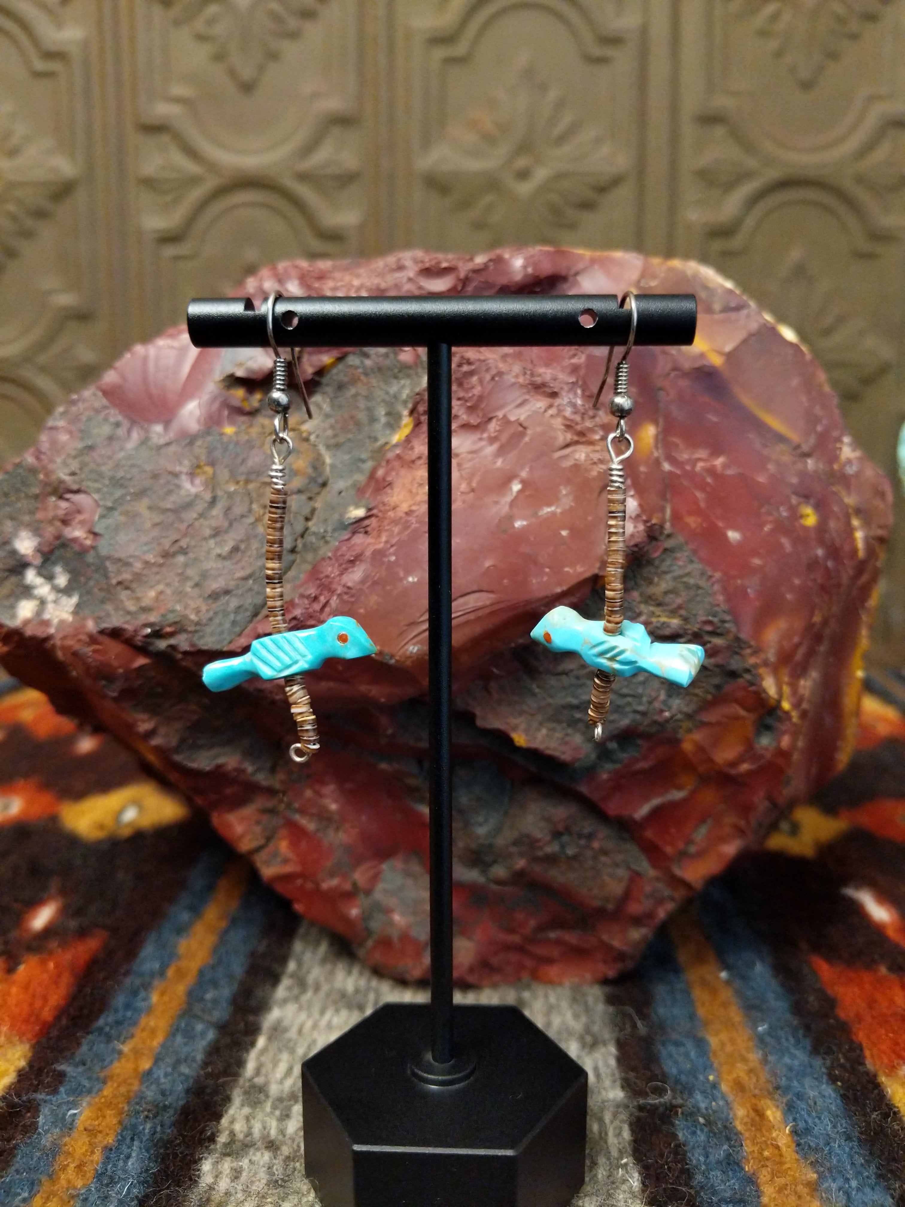 Dangle earrings showcase turquoise bird fetishes with heishi beads, on sterling silver hooks.