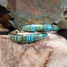 Handcrafted sterling silver Zuni turquoise hoop earrings by Keme Peina, featuring turquoise channel inlay with geometric accents.