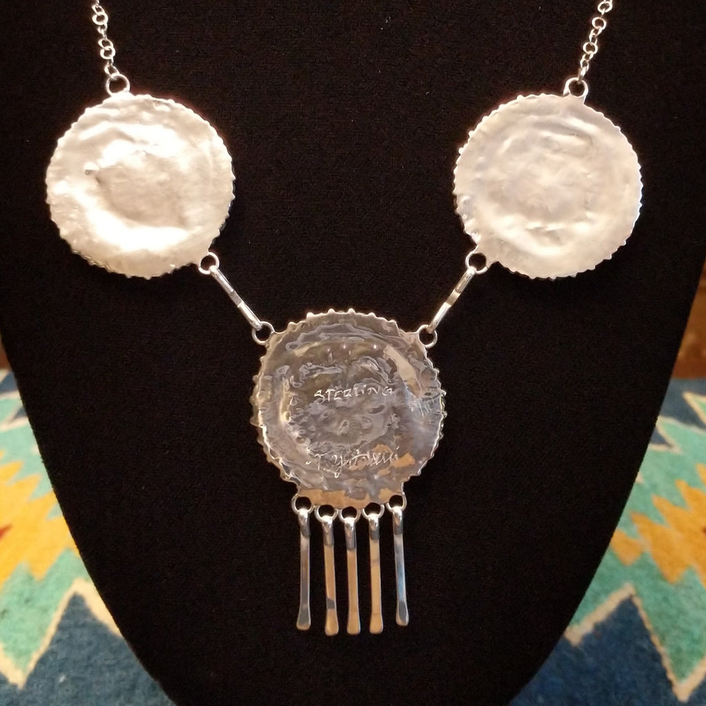 The back showcases the polished silver of the necklace pieces.