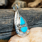 Sterling silver pendant with turquoise set in the bezel, framed by the hammered finish of the silver and snake design.