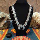 Sterling silver squash blossom naja and necklace and earrings set with turquoise set in individual bezels.