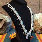 Sterling silver squash blossom naja necklace with turquoise set in individual bezels.