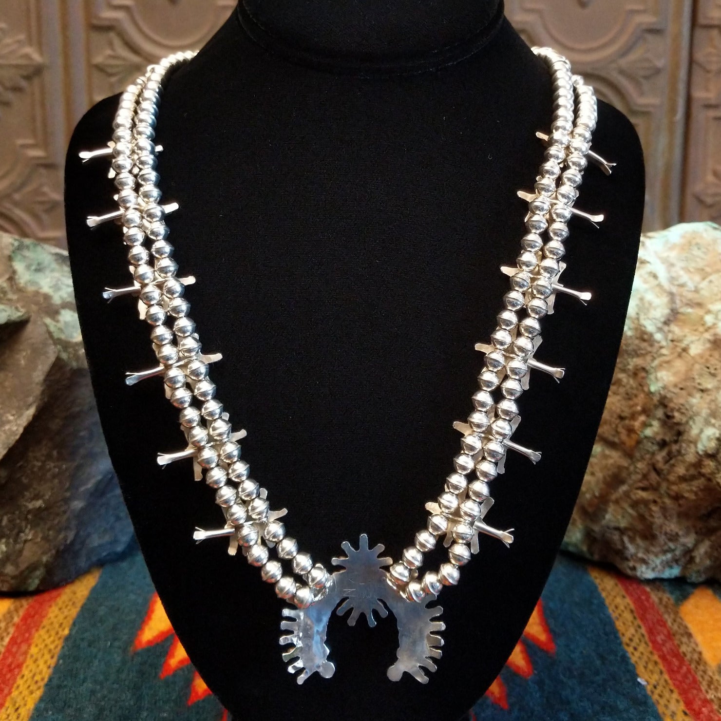 Sterling silver squash blossom naja necklace with turquoise set in individual bezels.