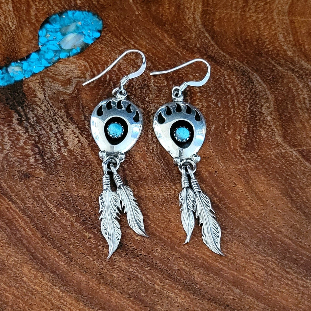 navajo made bear paw dangle earrings with feathers front view